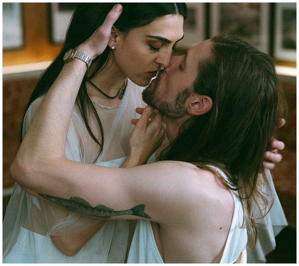 tattooed couple kissing in chair
